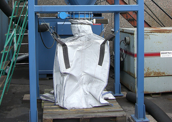 BEASS Filterabscheider, der Feinstaub oder Material in einen gesicherten industriellen Big Bag abführt, was eine saubere, manuelle Entleerung in einer fest installierten Vakuumsystemkonfiguration demonstriert.