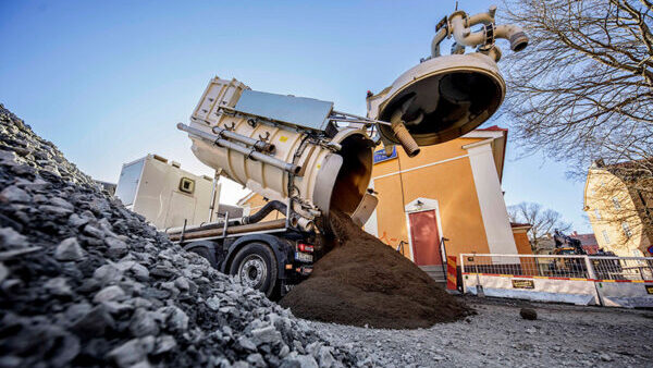 DISAB Centurion™ P20 Saugfahrzeug beim Entladen von Trockenmaterial auf einer Baustelle.