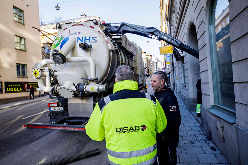 DISAB-Techniker schult einen Bediener im sicheren Umgang mit einem VacLoader auf einer Stadtstraße.
